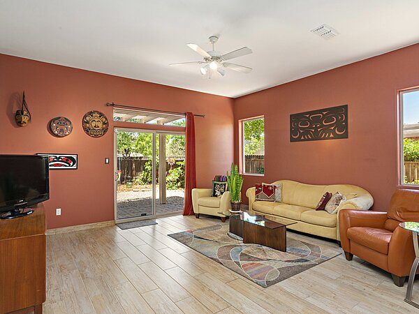 Spacious Living Room with Access to Fenced and Lush Backyard